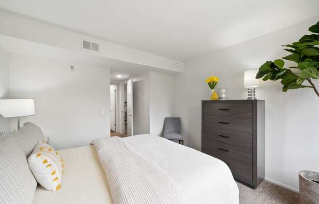 a bedroom with a large white bed and a dresser