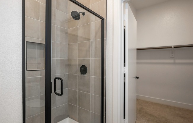 At Modera Trinity, step into luxury with standing showers embellished with striking black hardware, seamlessly blending modern design and functionality for a truly indulgent bathing experience.