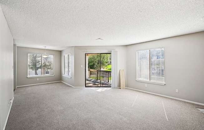 an empty living room with a door to a balcony