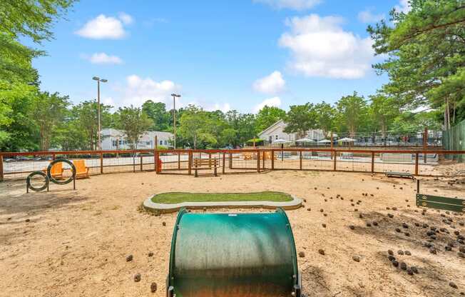 A playground with a green slide and orange swings.