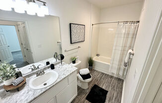 A bathroom with a sink, toilet, and shower.