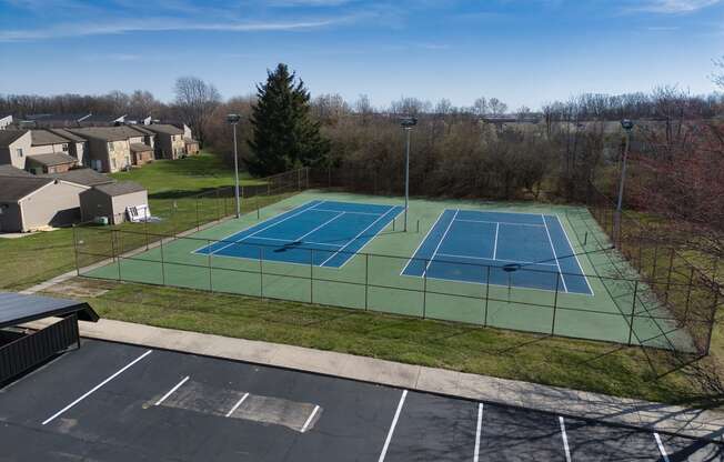 an aerial view of a tennis court with two tennis courts on a green tennis court