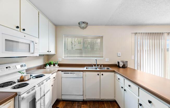 a kitchen with a stove a sink and a microwave
