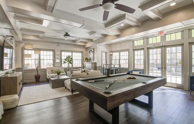 a large room with a pool table and couches