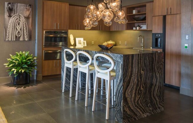 a kitchen with a center island and three stools at Regatta at New River, Fort Lauderdale, FL