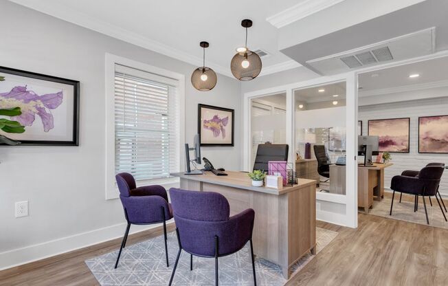 a living room with purple chairs and a reception desk