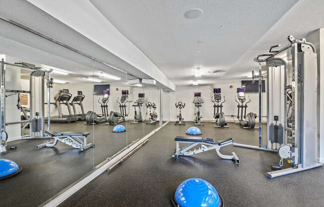 a fitness room with weights and cardio equipment at the grove apartments