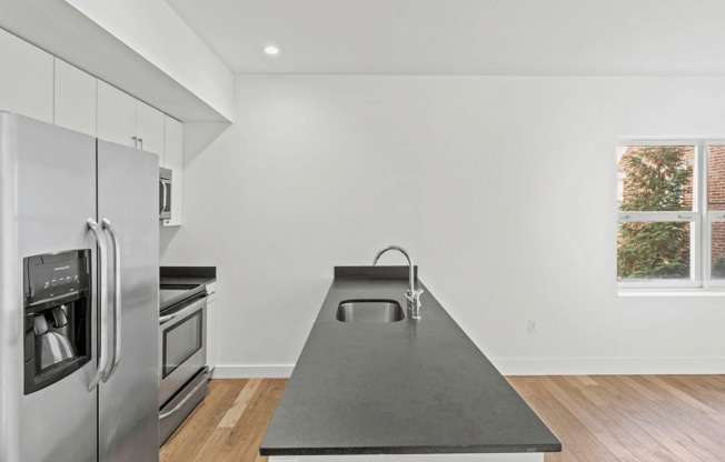 Embrace elegance in this sleek kitchen with top-tier appliances and abundant sunlight.