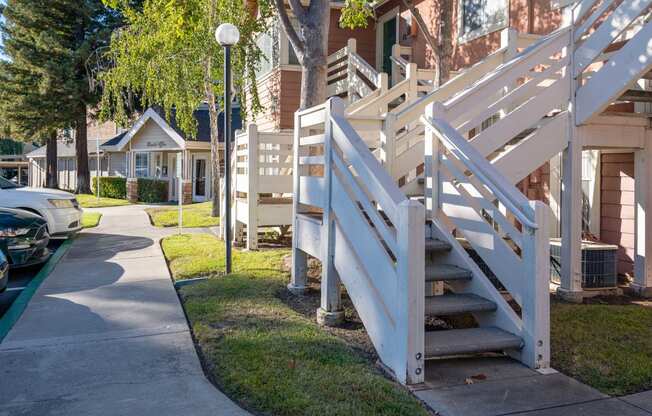 a sidewalk in front of a row of houses with stairs