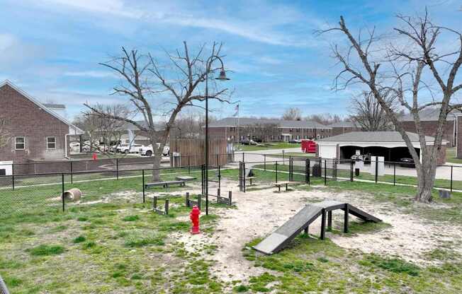 A playground with a slide, swings, and a red fire hydrant.