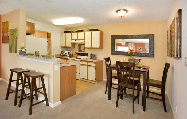an open kitchen and dining area with a dining table and chairs and a kitchen counter