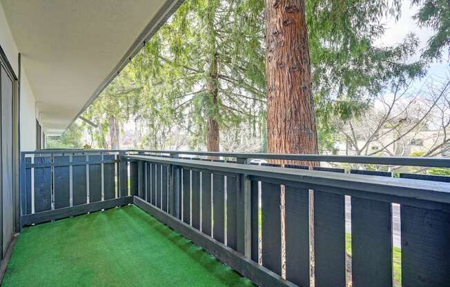 a balcony with a tree and green turf