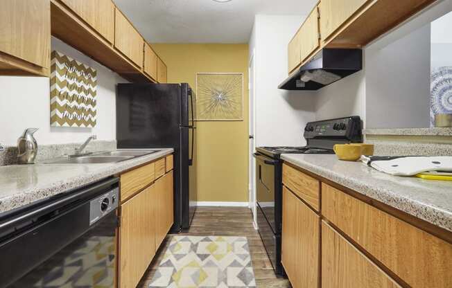 a kitchen with a black refrigerator freezer next to a stove top oven