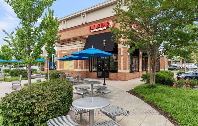 a patio outside of a restaurant with tables and umbrellas