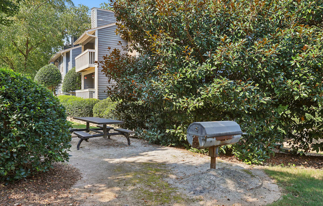 A picnic table is in front of a mailbox and a building.