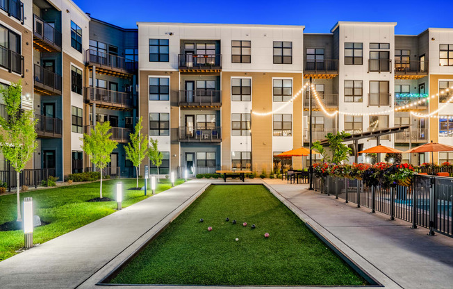 an exterior view of an apartment building with a grassy courtyard
