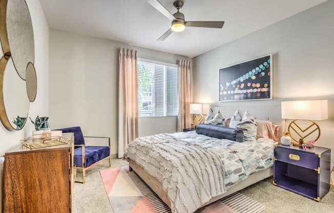 bedroom with ceiling fan bed and night stands at arte apartments