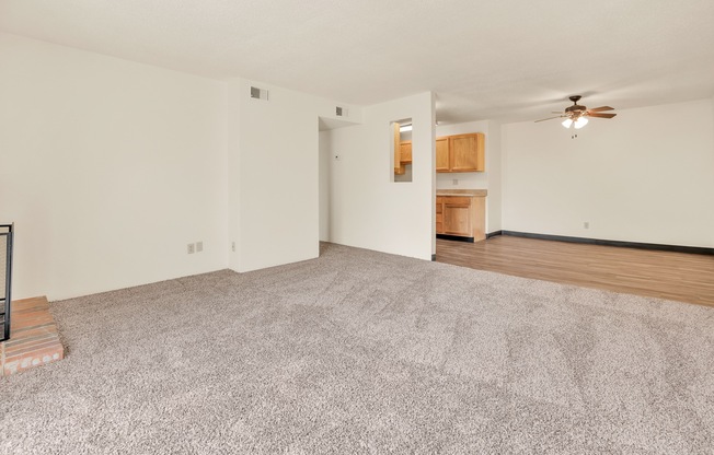 A room with a carpeted floor and a ceiling fan.