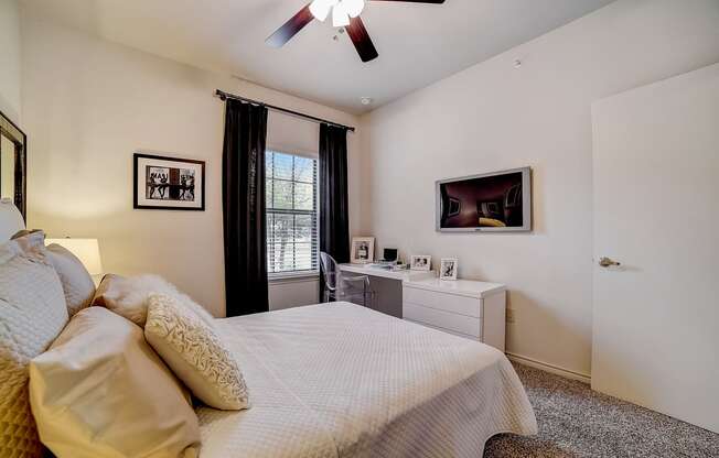 a bedroom with a large bed and a ceiling fan