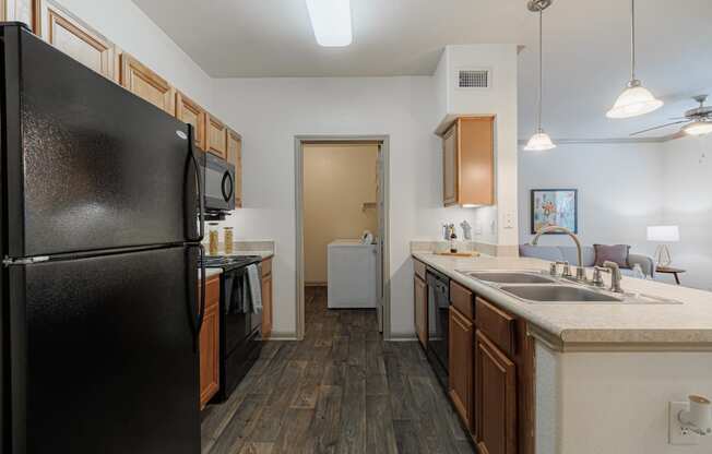 a kitchen with black appliances and a sink and a refrigerator