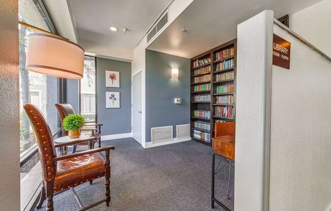 a room with a bookshelf and chairs