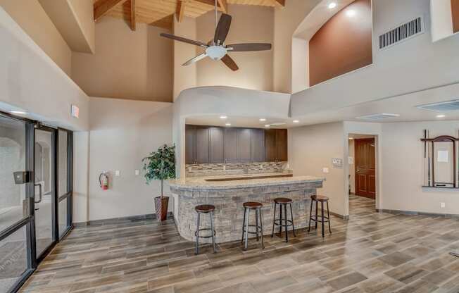 a kitchen with a bar and a ceiling fan