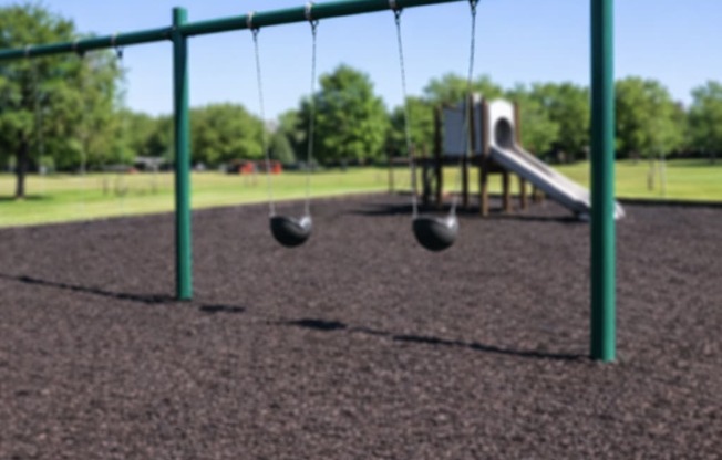 A playground with a swing set and a slide.