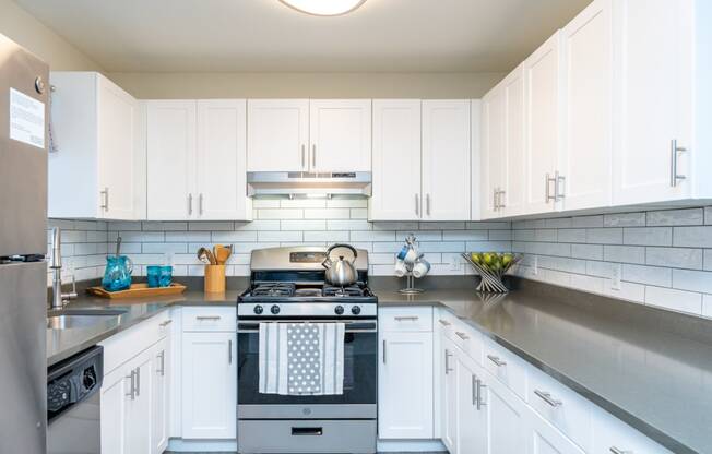 a white kitchen with stainless steel appliances and white cabinets