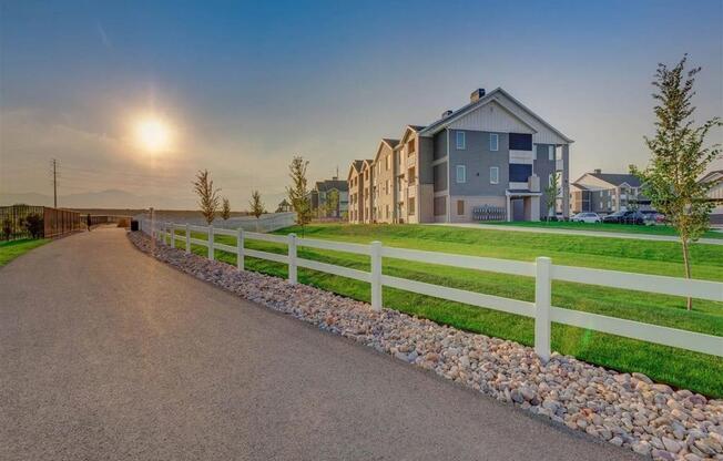 a road leading to a house with a white fence  at Affinity 56 Apartments in West Jordan, Utah