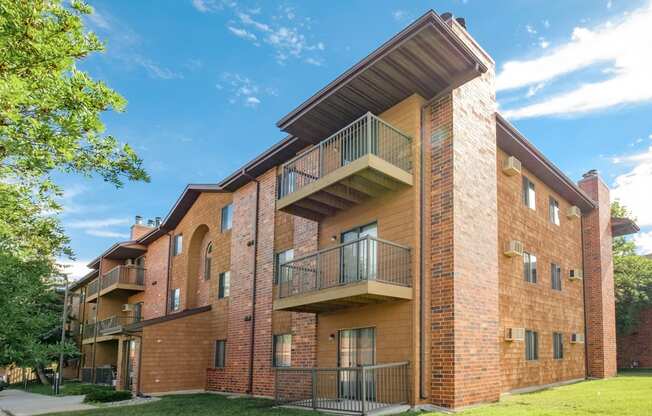 a brick apartment building with balconies and a blue sky. Fargo, ND Southview Village Apartments