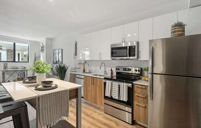 A kitchen with stainless steel appliances and a dining table at Bay Village 1 Apartment in Palmetto Bay, FL