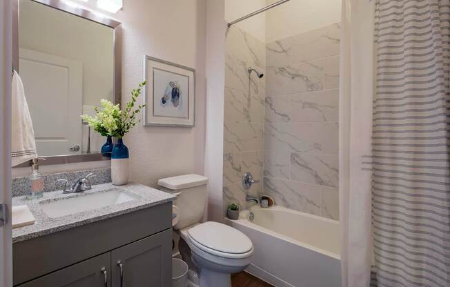 A bathroom with a toilet, sink, and bathtub.