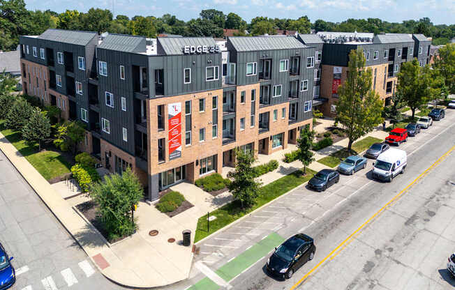 A street view of a parking lot with cars and a building with a sign that says "EDGE".
