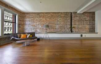 an exposed brick wall in a living room with a couch and a chair