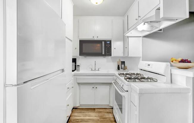 a white kitchen with a stove and a refrigerator