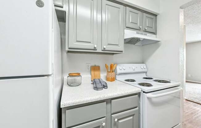 A kitchen with white appliances and cabinets.