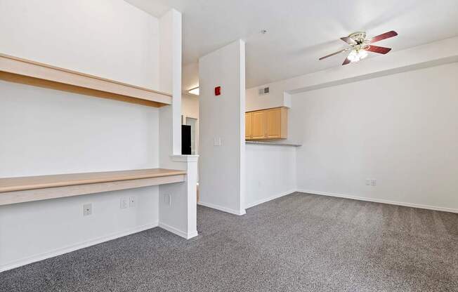 A room with a ceiling fan and a door leading to another room.
