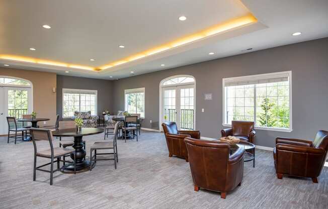 a lounge area with leather chairs and tables and windows