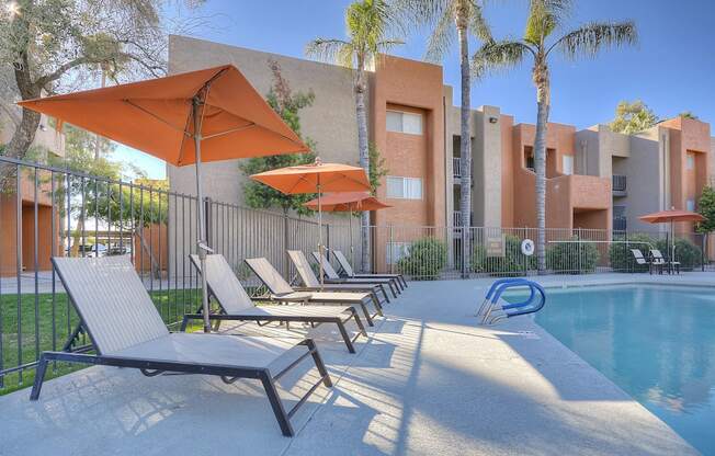 A poolside area with sun loungers and umbrellas.