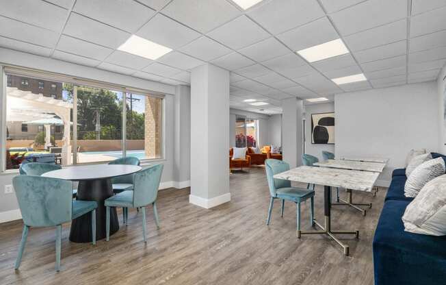 a common room with a couch table and chairs and a large window