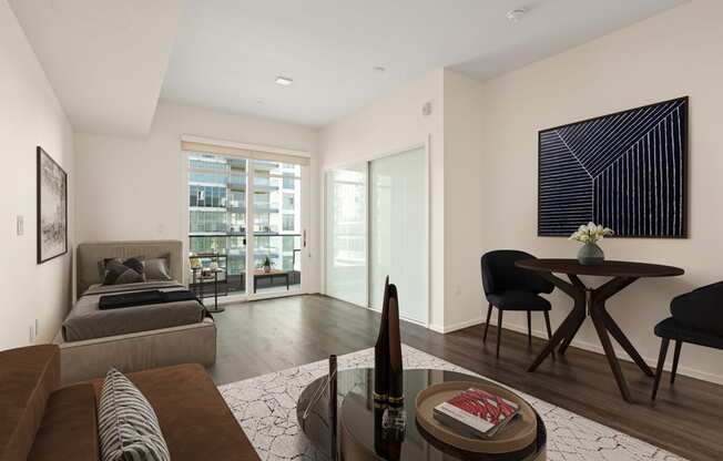 A modern living room with a grey sofa, a black chair, a coffee table, and a painting on the wall.
