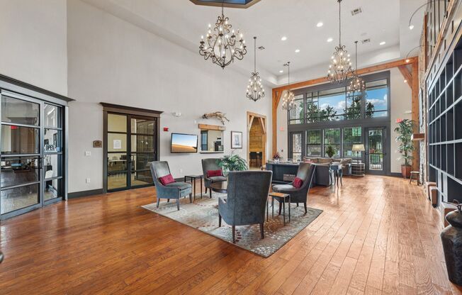 A large room with wooden floors and a chandelier hanging from the ceiling.