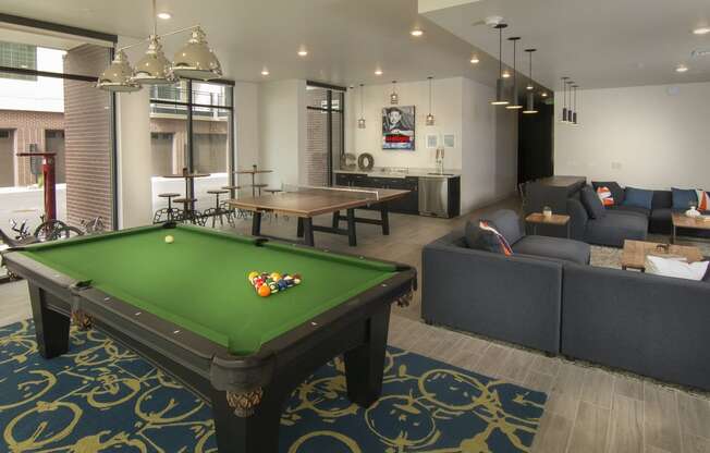 a games room with a pool table and couches