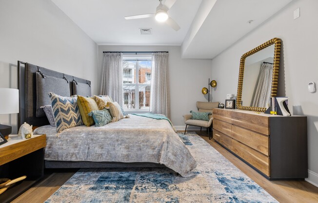 a bedroom with a bed and a dresser and a window