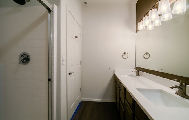 a bathroom with two sinks and a walk in shower