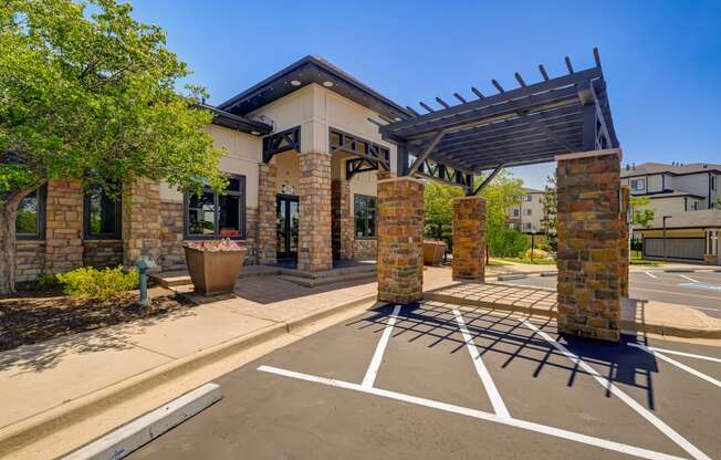 an empty parking lot in front of a building with awnings at The Fletcher Southlands, Aurora, CO