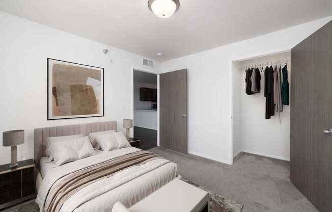 A bedroom with a bed, a painting, a wardrobe, and a chair.