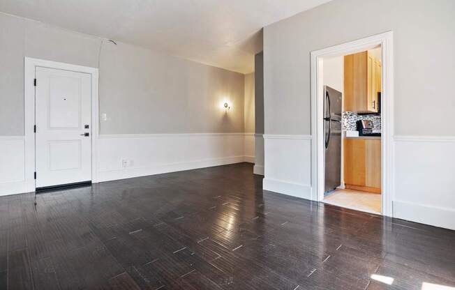 A studio apartment with a white door and a wooden floor at Brookmore.