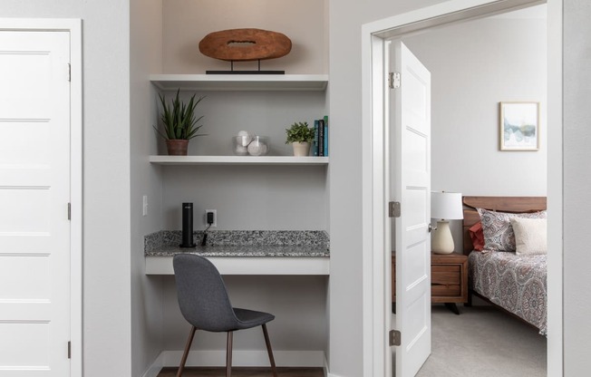 A small room with a bed, desk, and chair.