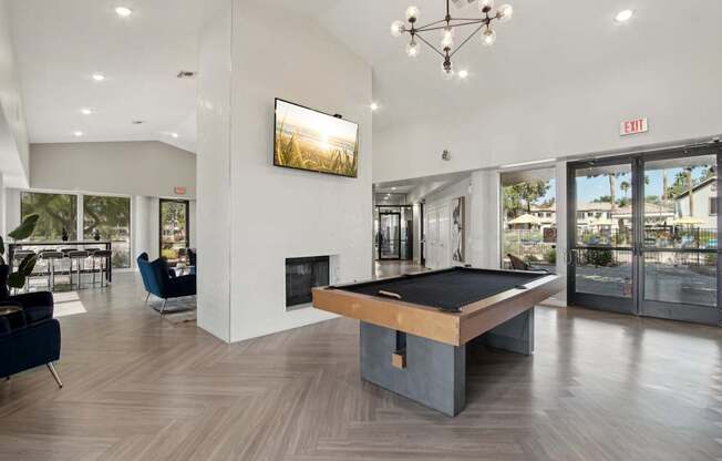 A room with a pool table and a fireplace.